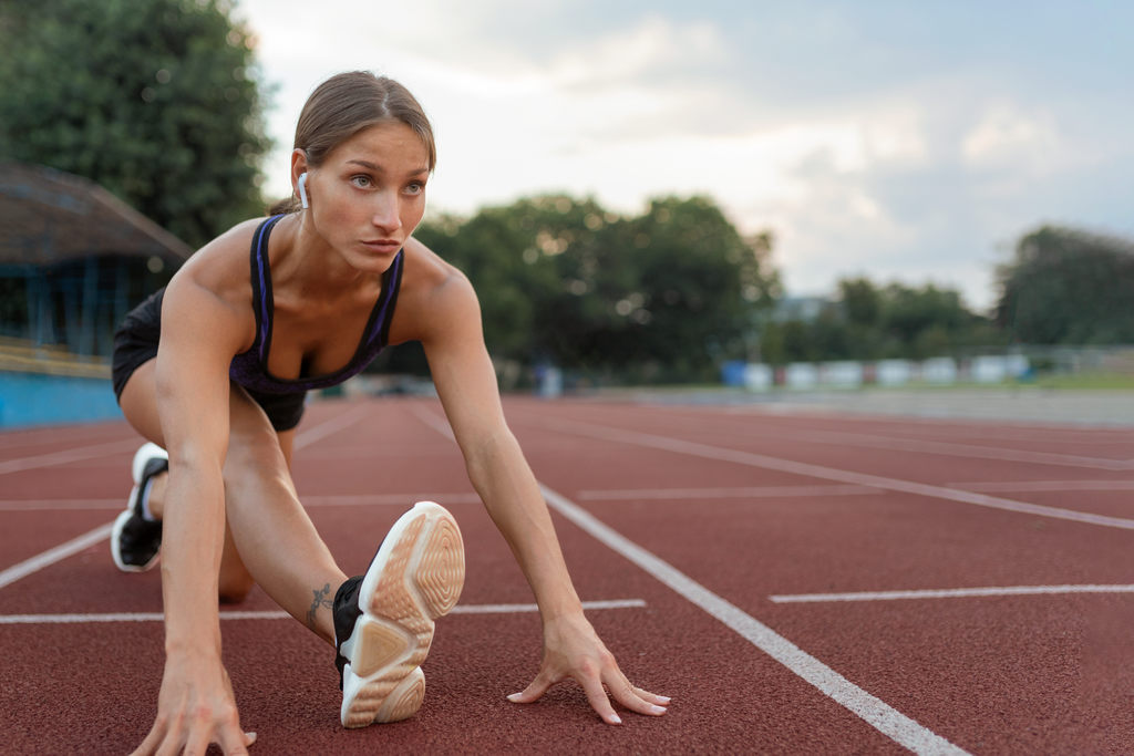 Mulher atleta em linha de largada, se preparando para uma corrida, simbolizando aposentadoria no esporte