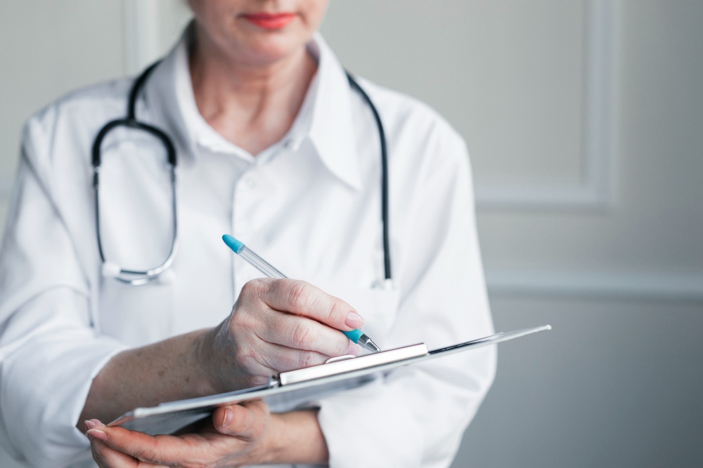 Médica com papel e prancheta nas mãos, possivelmente fazendo um laudo de perícia resolutiva
