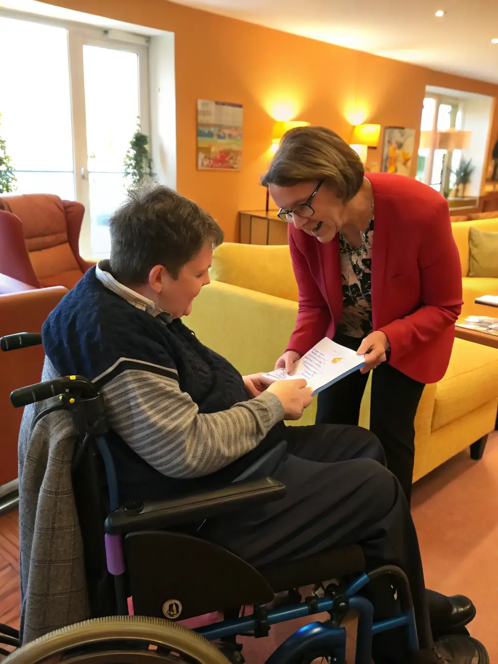 A person in a wheelchair receiving assistance from a social worker, representing disability and sick leave assistance.