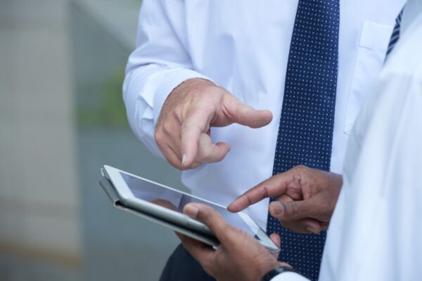 Advogado previdenciário e médico analisando planejamento de aposentadoria especial médico em um tablet.
